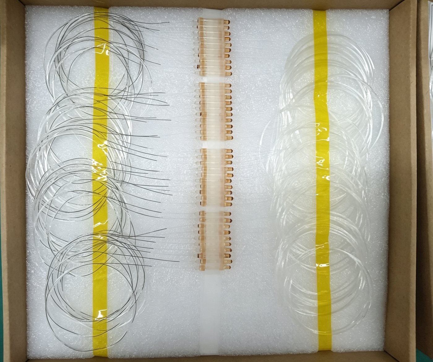 1x2 FWDM devices packed for shipment, showing three fiber legs per unit before connectorization