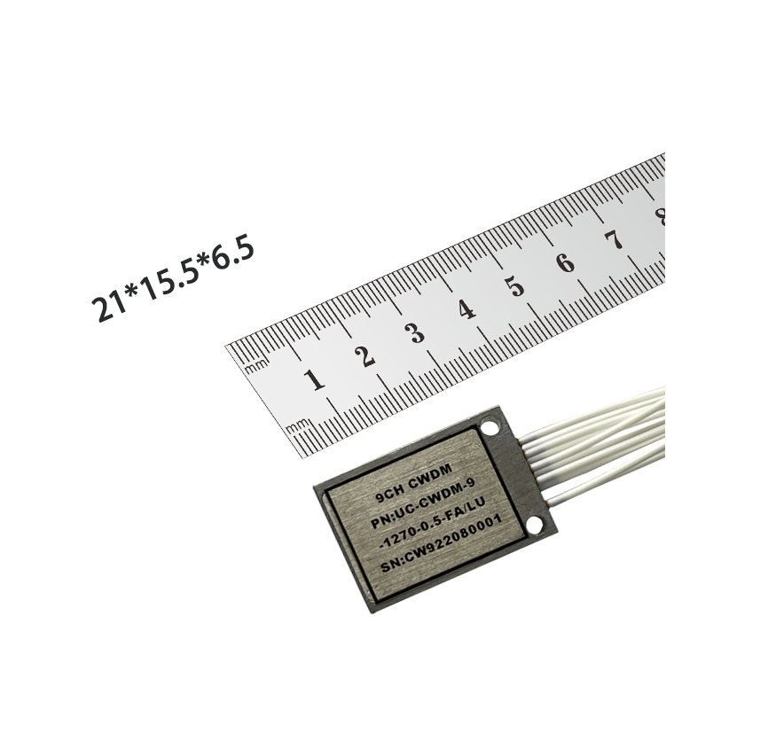 9-channel UCWDM device measured against a steel ruler, 21 by 15.5 by 6.5 millimeters, part number UC-CWDM-9-1270-0.5-FA/LU